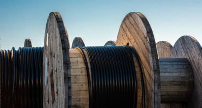 Black cable on large wooden drums.